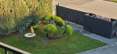 a garden with trees and a table and a fence at Apartment ZOI in Ptuj