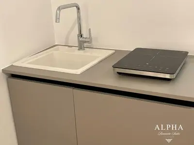 a kitchen with a sink and a laptop on a counter at Alpha Romantic Suites Ljubljana in Ljubljana