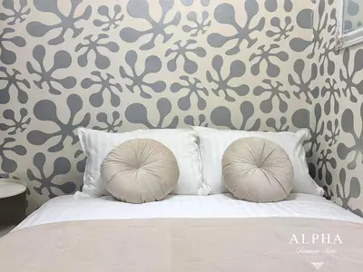 two pillows on a bed with a floral wallpaper at Alpha Romantic Suites Ljubljana in Ljubljana