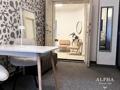 a room with a table and chairs and a mirror at Alpha Romantic Suites Ljubljana in Ljubljana