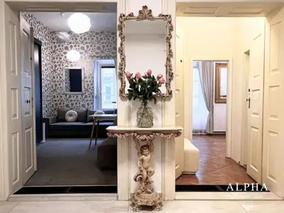 a hallway with a mirror and a vase of flowers on a table at Alpha Romantic Suites Ljubljana in Ljubljana