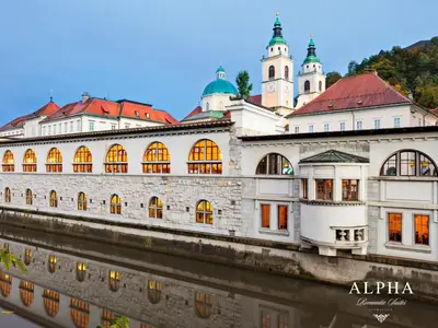 a building on the side of a river at Alpha Romantic Suites Ljubljana in Ljubljana