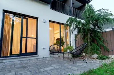 two chairs sitting on a patio in front of a house at Anur Apartment in Ptuj