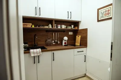 a kitchen with white cabinets and a sink at Anur Apartment in Ptuj