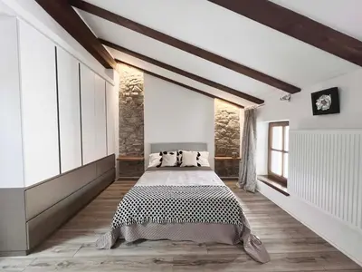 a bedroom with a large bed in a room with wooden floors at Tranquil Escape in Vipava