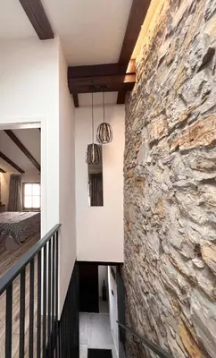a room with a stone wall next to a bedroom at Tranquil Escape in Vipava