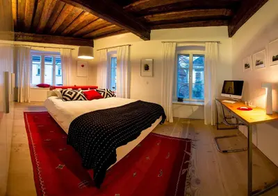 a bedroom with a large bed with a red rug at FishSquare in Ljubljana