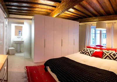 a bedroom with a large bed with white cabinets at FishSquare in Ljubljana