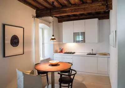 a small kitchen with a wooden table and chairs at FishSquare in Ljubljana