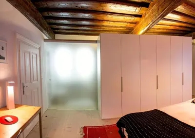a bedroom with white cabinets and a wooden ceiling at FishSquare in Ljubljana