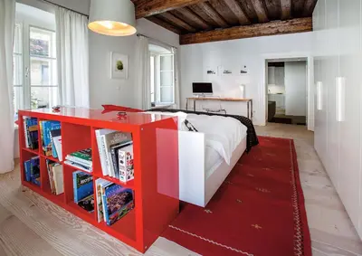 a bedroom with a large bed and a red desk at FishSquare in Ljubljana