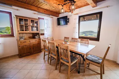 a dining room with a wooden table and chairs at Holiday Home Sunny at vineyard in Veliki Kamen