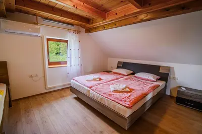 a bedroom with a large bed and a window at Holiday Home Sunny at vineyard in Veliki Kamen