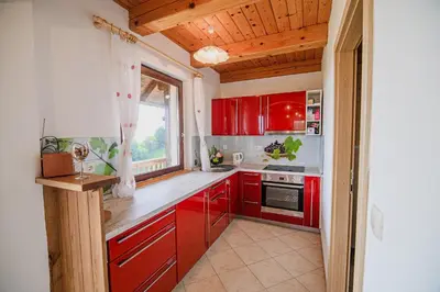 a kitchen with red cabinets and a window at Holiday Home Sunny at vineyard in Veliki Kamen