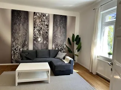 a living room with a blue couch and a table at Luxury Apartment Privoz in Ljubljana