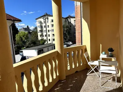 a balcony with a table and chairs and a view of a city at Luxury Apartment Privoz in Ljubljana