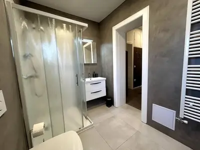 a bathroom with a glass shower and a sink at Luxury Apartment Privoz in Ljubljana
