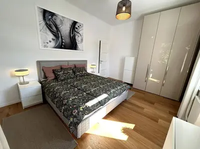 a bedroom with a bed and a painting on the wall at Luxury Apartment Privoz in Ljubljana