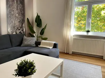 a living room with a blue couch and a table at Luxury Apartment Privoz in Ljubljana