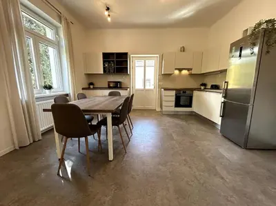 a kitchen with a table and chairs and a refrigerator at Luxury Apartment Privoz in Ljubljana