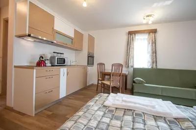 a kitchen with a bed and a table in a room at Tourist farm Megušar in Škofja Loka