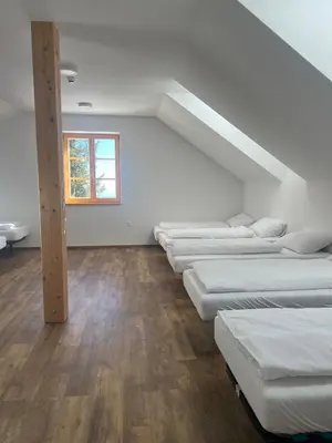 a row of beds in a room with a window at Mozirska koča in Mozirje
