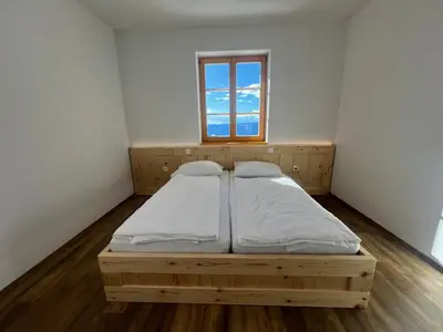 a bed in a room with a window at Mozirska koča in Mozirje