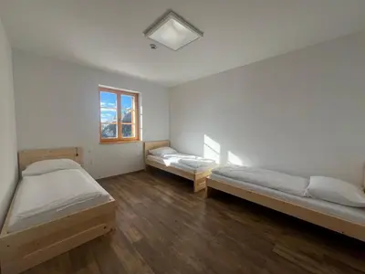a room with two beds and a window at Mozirska koča in Mozirje
