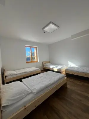 a room with three beds and a window at Mozirska koča in Mozirje