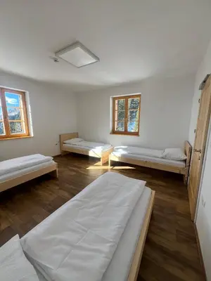 a room with three beds and two windows at Mozirska koča in Mozirje