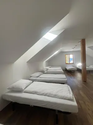 a row of beds in a room with a attic at Mozirska koča in Mozirje