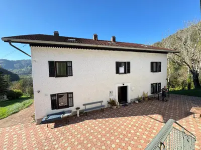 a white house with a bench in front of it at Hisa Pelance in Tolmin