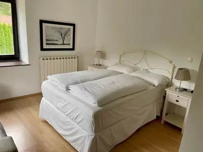 a bedroom with a bed with white sheets and a lamp at Hisa Pelance in Tolmin