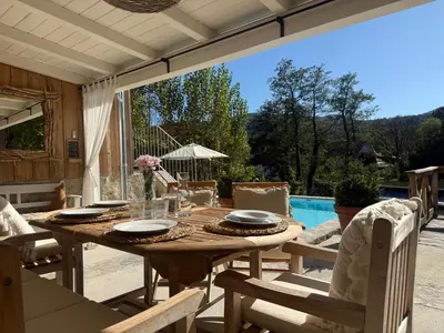 a table and chairs on a patio with a pool at PAVI APARTMENTS River Estate Krka in Krka