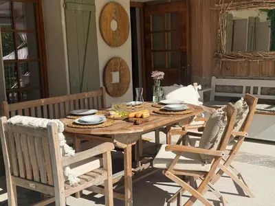 a wooden table and chairs on a patio at PAVI APARTMENTS River Estate Krka in Krka