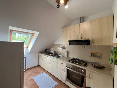 a kitchen with white cabinets and a stove top oven at Apartments and Rooms Tajcr in Bovec
