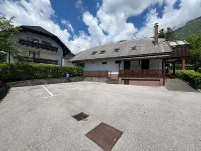 a building with a parking lot in front of it at Apartments and Rooms Tajcr in Bovec