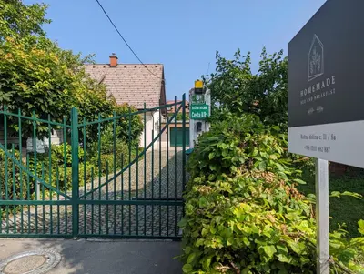 a gate with a sign in front of a building at Cozy house close to Ljubljana center in Ljubljana