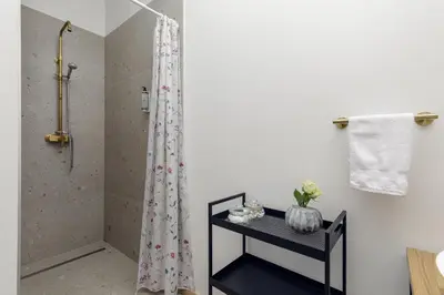 a bathroom with a shower and a black table at Cozy house close to Ljubljana center in Ljubljana