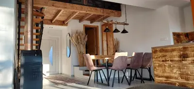 a dining room with a wooden table and chairs at Hiša Galeria in Loče pri Poljčanah