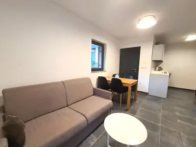 a living room with a couch and a table at Alpine Escape Golte Apartment in Mozirje