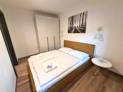 a small bedroom with a bed with a table at Alpine Escape Golte Apartment in Mozirje