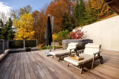 a patio with chairs and an umbrella on a wooden deck at Chalet Jasna in Kranjska Gora