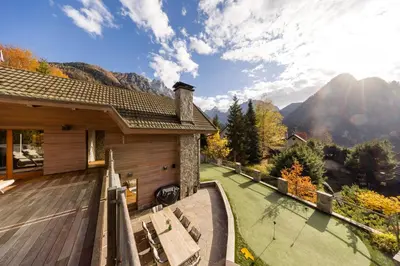 a house with a deck with a view of mountains at Chalet Jasna in Kranjska Gora