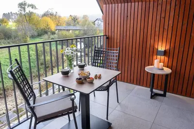 a table and two chairs on a balcony with a view at Hiša Janko in Dolenjske Toplice