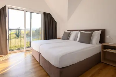 a bedroom with a large bed with a large window at Hiša Janko in Dolenjske Toplice