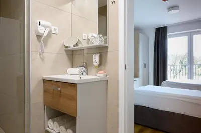 a bathroom with a sink and a bed and a mirror at Hiša Janko in Dolenjske Toplice
