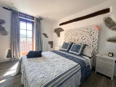 a bedroom with a bed and a large window at Historic Wine-Stone House in Vipava
