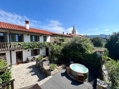 a house with a bath tub in a yard at Historic Wine-Stone House in Vipava