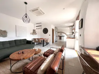 a living room with a green couch and a table at Historic Wine-Stone House in Vipava
